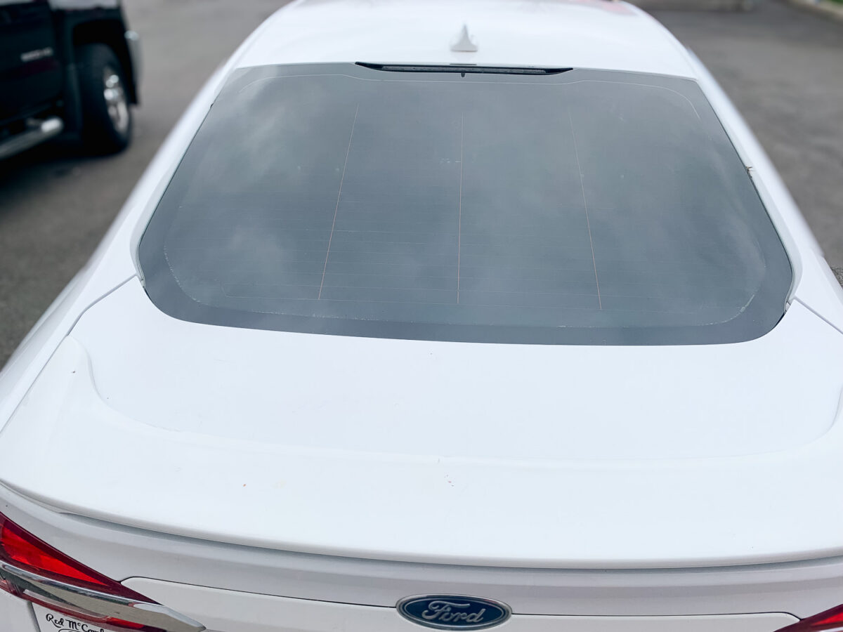 Rear view of a white Ford sedan with tinted back window film for added privacy, heat rejection, and UV protection