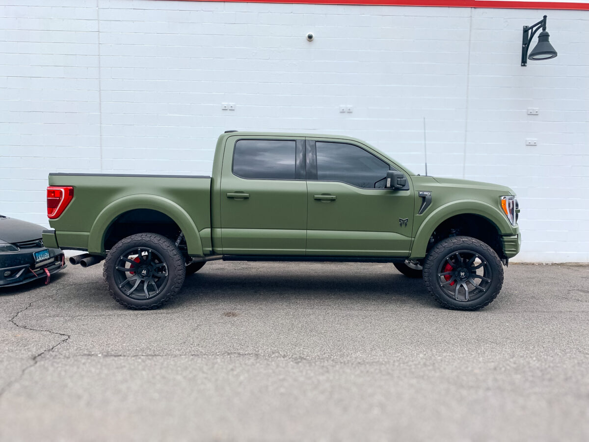 Side view of a green pickup truck with dark tinted side windows for added privacy and UV protection.