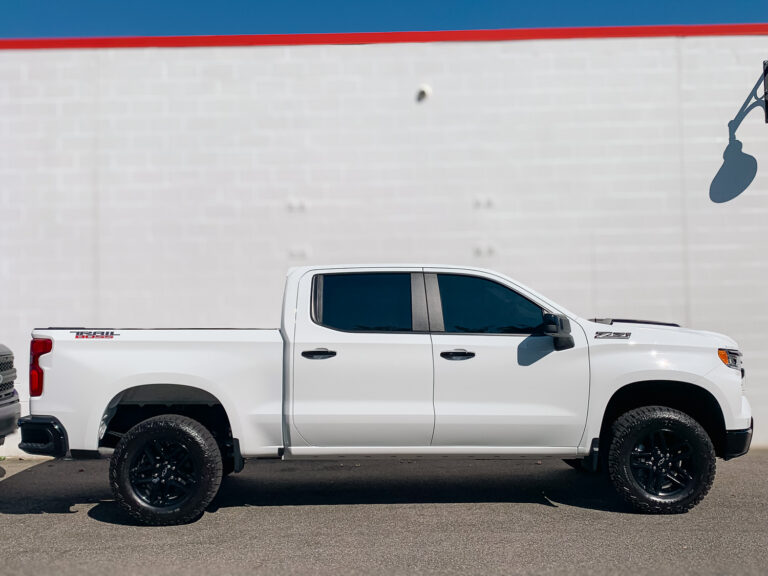 White pickup truck with dark tinted side windows, showcasing window tint for privacy and UV protection