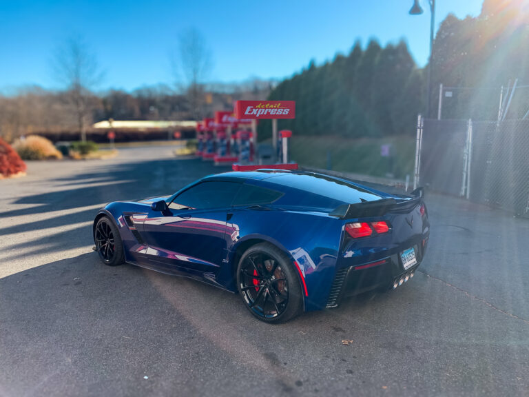 Blue sports car with dark tinted side and rear windows, showcasing automotive window tint for privacy and UV protection