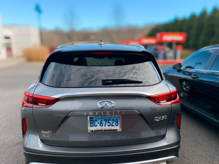 Rear view of a gray Infiniti QX50 with dark tinted rear glass for added privacy and UV protection