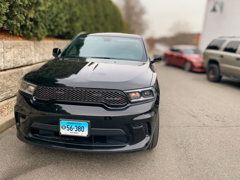 Front view of a black Dodge SUV with tinted windshield strip and dark side windows for added privacy and UV protection.