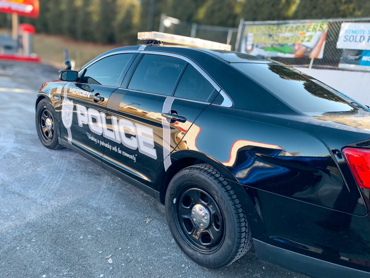 Black police sedan with dark tinted side and rear windows
