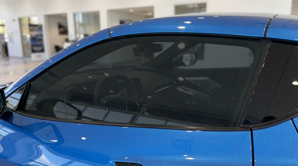 Blue car side window with dark window tint film for added privacy and UV protection