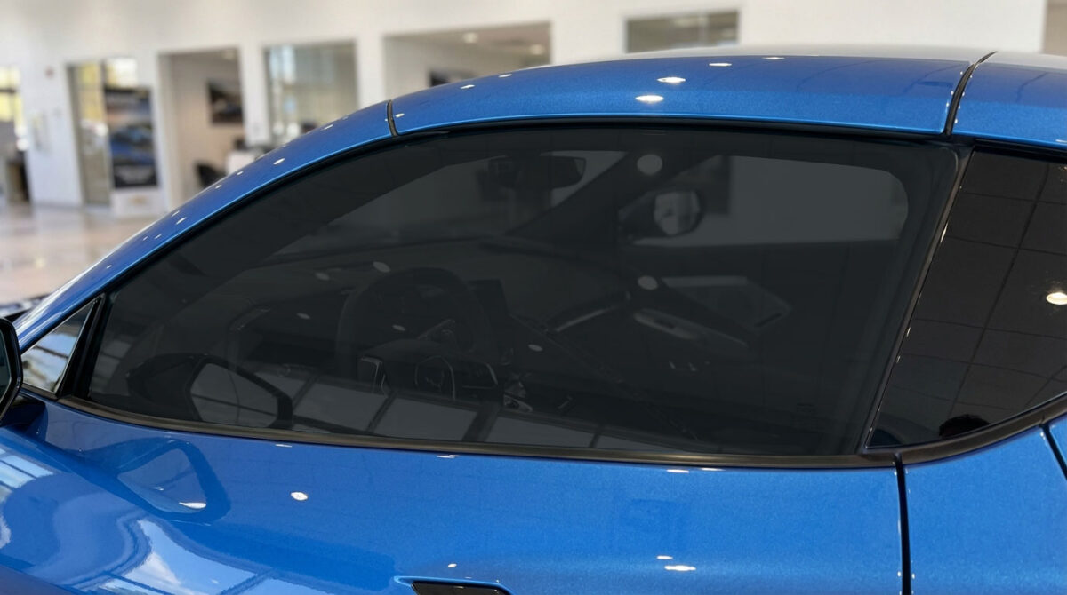 Blue car side window with dark window tint film for added privacy and UV protection